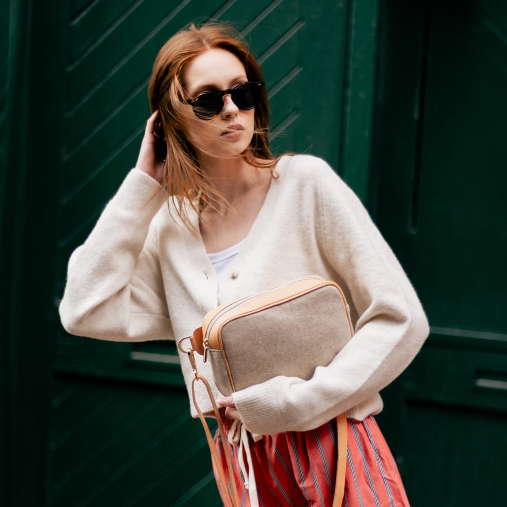 Woman in sunglasses carrying the Natural Italian Wool Crossbody Bag in the Distillery District